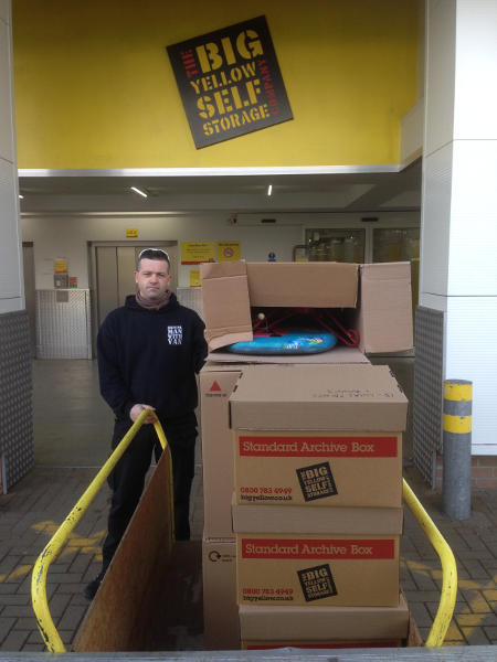 Man With Boxes using Removal Trolley outside of Storage Facility